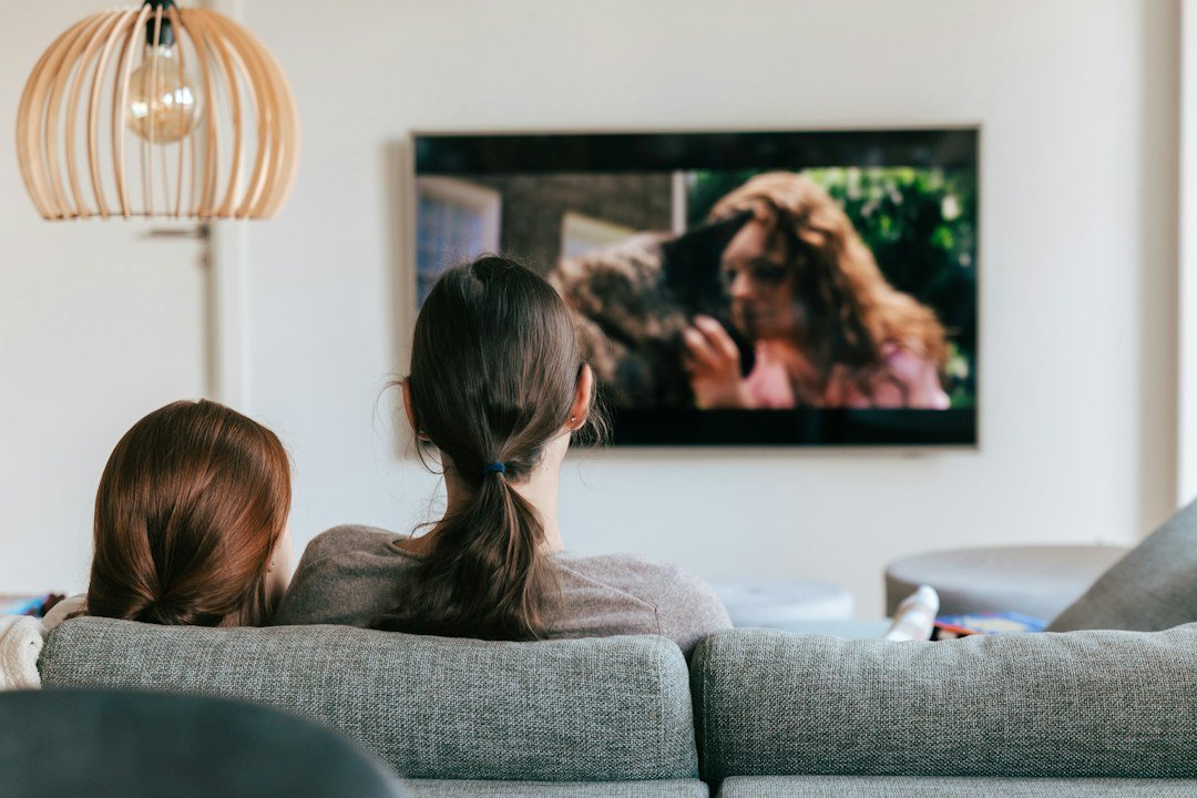 Casal assistindo conteúdo na televisão em casa